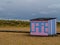 Wooden walkway to beach and horizon with beach huts and dunes