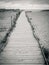 Wooden walkway to beach and horizon with beach huts and dunes