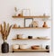 Wooden wall floating shelves with home decorative pieces. Storage organization for home. Interior design of modern living room.
