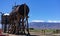 A wooden water tank and a metal fuel tank in an antique railway yard in the Owens Valley, California