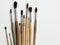 wooden watercolor brushes lie on a white canvas