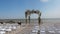 Wooden wedding arch on the seashore in rustic style.