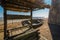 The wooden well, old holey boat on the seashore on a sunny day