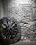 Wooden wheel near a stone wall