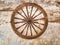 Wooden wheel on an old shabby wall
