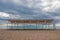 Wooden white sunshades and sand beach with azure sea, cloudy sky background The end of the beach season. Empty beach with