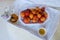 on wooden white tray plate with orange apricots, peach, bunch of wild flowers on table, beautiful summer still life, fruits,