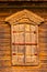 Wooden window with closed shatters made of weathered wood