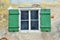 Wooden window with green blinds in an old building