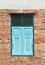 Wooden window shutter cyan in a traditional brickwork exterior w