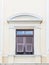 Wooden window with shutters open on light yellow wall