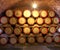 Wooden wine barrels are stored in winery cellar