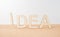 Wooden word ` idea ` with exclamation mark on wooden desktop and white background