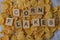 Wooden word lies on a pile of dry cornflakes