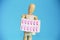 Wooden yellow mannequin holds pink medical pills