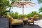 Wooden, yellow sofa couch with umbrella at the outdoor patio. With green tree and blue sky nature background