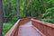 Wooden zigzag boardwalk across mature forest.