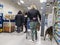 Woodinville, WA USA - circa February 2022: View of several people and a woman with her dog waiting in the checkout lines inside of