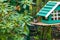 A woodpecker gathers food from a  bird house and sits on a table next to the house