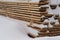 Woodpile stacked of firewood under the snow. Stack of cut wood under the snow
