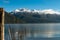 Woods of an old pier with a snowy mountain range in the background. Gutierrez Lake, Los Alerces National Park