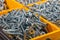 Woodscrews. Pile of wood screws sorted in yellow box storage con