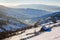 Woodshed on the hillside in winter mountains