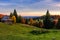 Woodshed and trees on hillside meadow at sunset