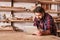 Woodwork craftsman in his studio using a digital tablet