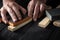 Woodworker cleans the wood plank with an abrasive tool. Builder hands close up. Renovation or construction idea