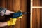 Woodworker drills a hole with an electric drill in a wood board. Closeup of foreman hand at work. Working environment in carpentry