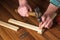 Woodworker hammers a nail into a plank with a hammer. Hands of the master close-up. Working environment in a carpentry workshop