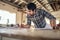 Woodworker leaning on a workbench in his studio reading blueprints