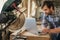 Woodworker working online by a mitre saw in his workshop