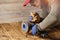 Woodworking. Young  Man Brushing old wooden table  with an electric rotary brush grinder. On the hand he wearing protective gloves