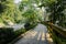 Woody planked footpath with balustrade along road on sunny day