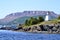 Woody Point Lighthouse along the shore of Bonne Bay with The Tablelands on the horizon