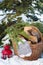 Wool mittens on the basketful of firewood near snowy Christmas-tree and a red lantern