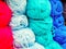 Woolen yarns in light blue, turquoise and pink. Photo in close-up full screen