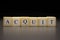 The word ACQUIT written on wooden cubes isolated on a black background