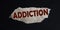 The word addiction is written on brown cardboard