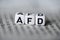 Word AFD formed by wood alphabet blocks on newspaper german party politics