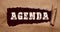 The word Agenda appearing behind torn brown paper. Conceptual image