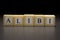The word ALIBI written on wooden cubes isolated on a black background