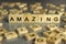 Word amazing is made of square wooden letters on a gray background