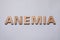 Word Anemia made of wooden letters on grey background, flat lay