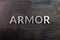 The word armor laid with silver metal letters on rusted iron flat surface background