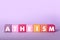 Word Atheism made of cubes with letters on violet background
