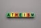 Word Atheism made of wooden cubes with letters on grey table, top view