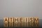 Word Atheism made of wooden cubes with letters on mirror surface